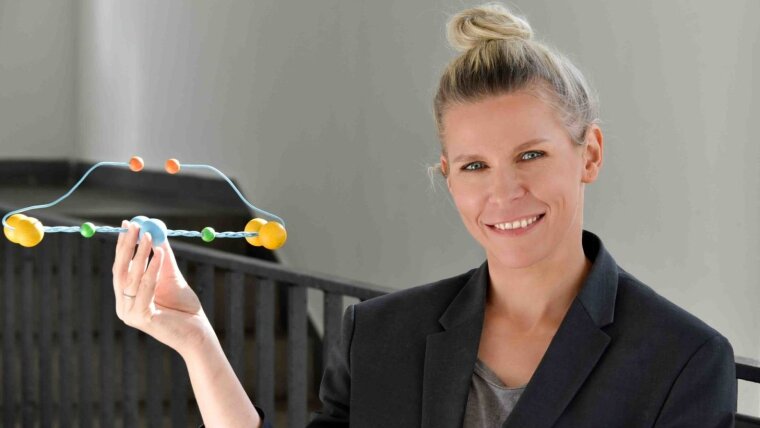 Materials scientist Dr habil. Izabela Firkowska-Boden holds a fibrinogen protein model.